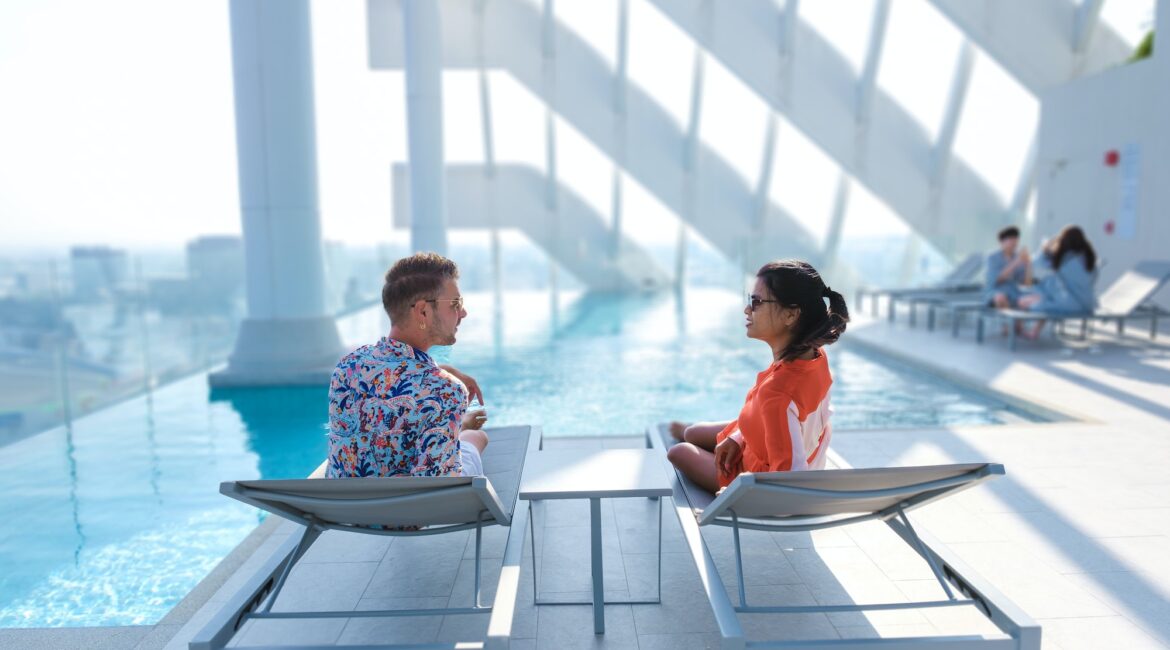 couple men and women relaxing at a rooftop pool of a luxury hotel